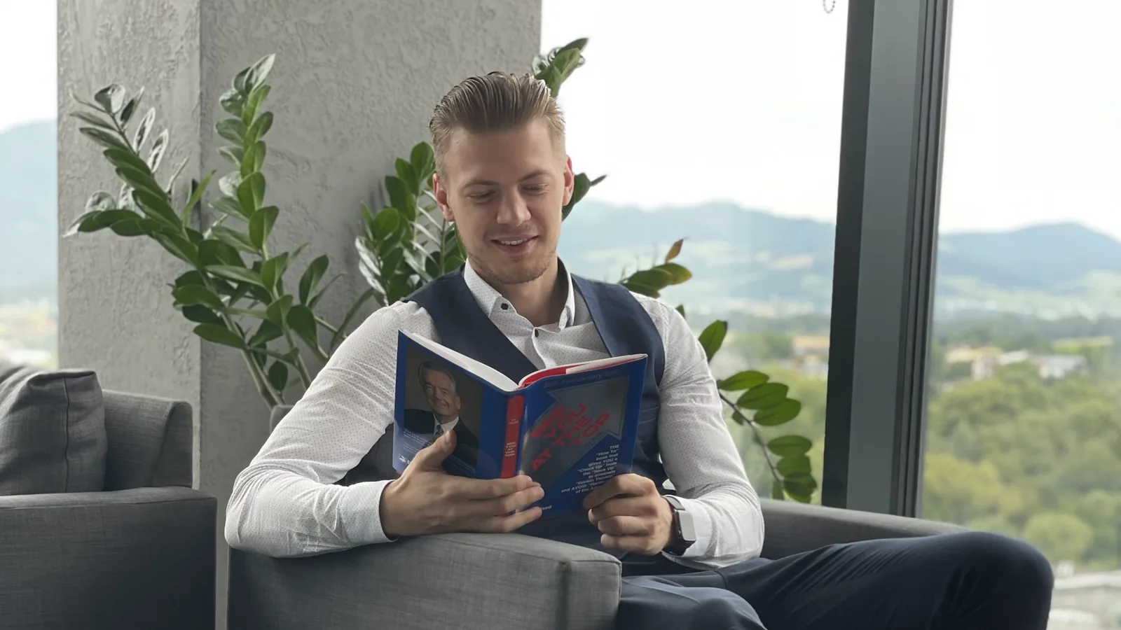 Marián Váňa s knihou v kresle